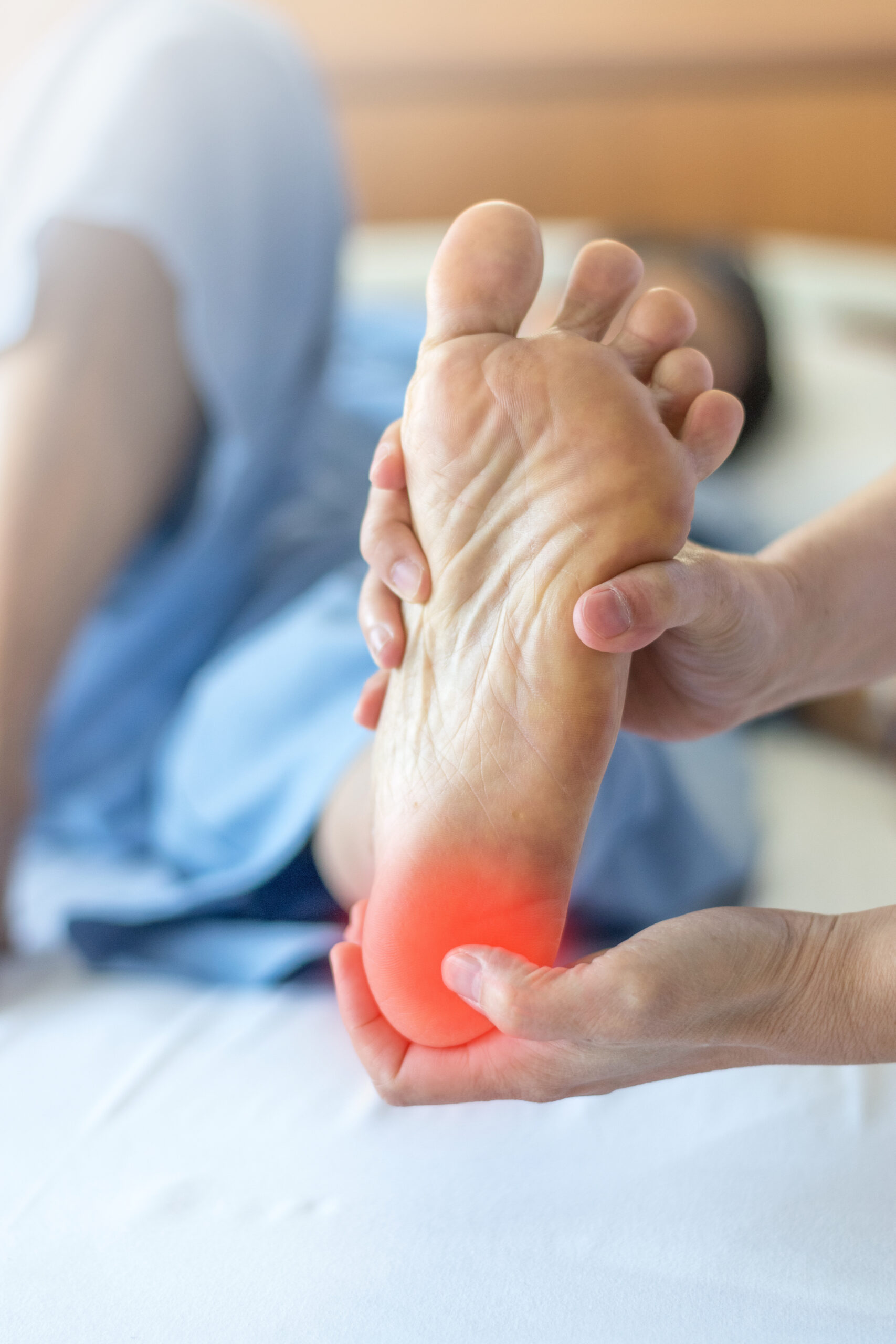 Koncepcja bólu pięty lub zapalenia rozcięgna podeszwowego. Ręka na stopie symbolizująca cierpienie z powodu problemów z zapaleniem stopy, takimi jak choroba Severa czy apofizytis piętowy.