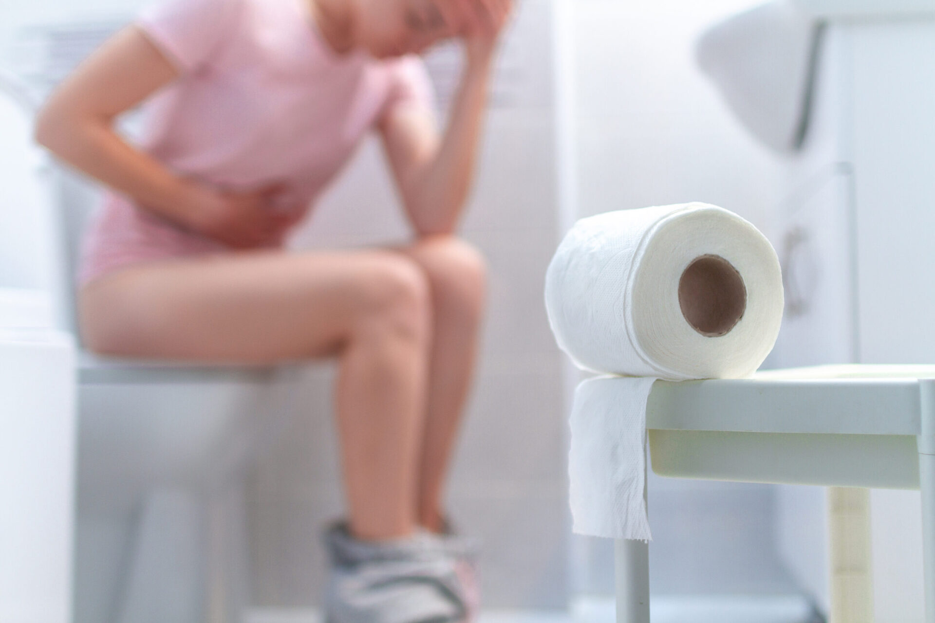 Chora, niedysponowana kobieta cierpiąca na biegunkę, zaparcia i zapalenie pęcherza moczowego na toalecie. Ból brzucha podczas zespołu napięcia przedmiesiączkowego (PMS). Koncepcja opieki zdrowotnej i bólu.