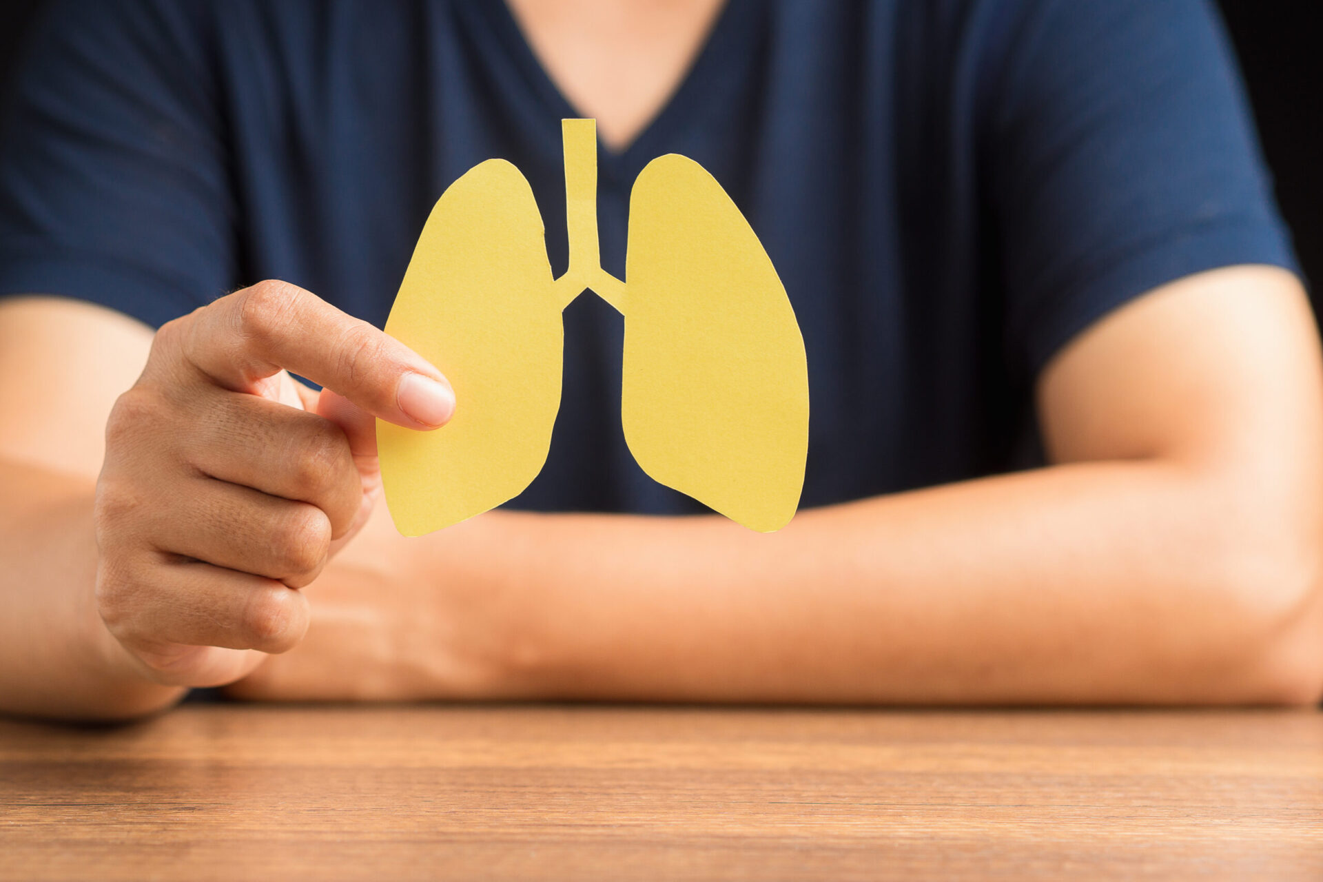 Zbliżenie dłoni mężczyzny trzymającego symbol płuc, siedzącego w szpitalu. Światowy Dzień Gruźlicy, Światowy Dzień Bez Tytoniu, rak płuc, nadciśnienie płucne, zapalenie płuc, COVID-19. Zdjęcie z bliska.